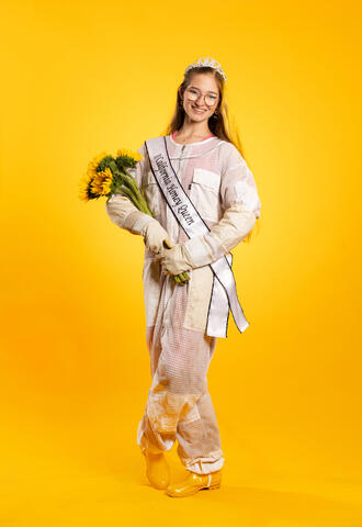 Emilia Burnham in beekeeper boots with sunflowers