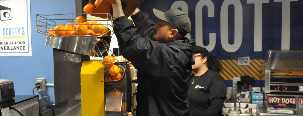 Employee making OJ at Scotty's store