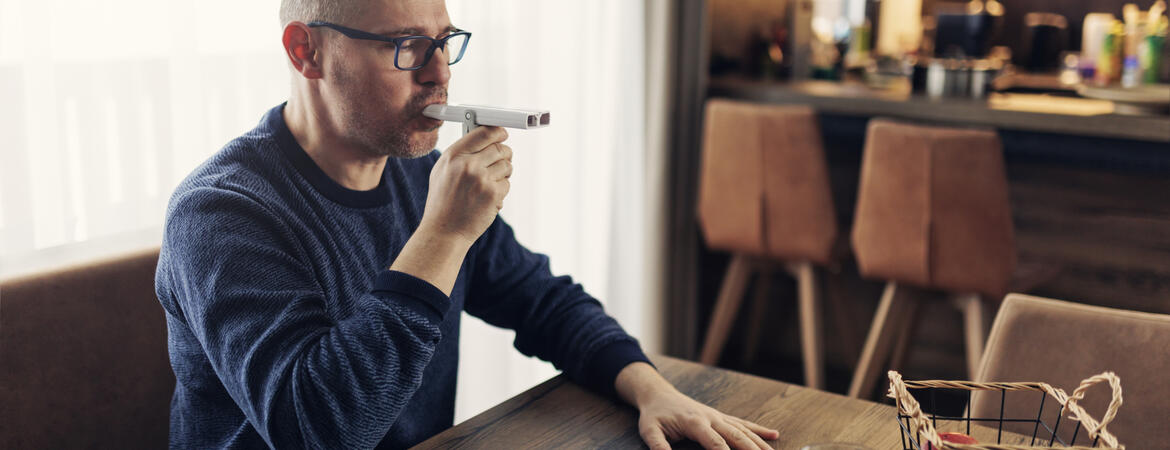 Man using a peak flow meter