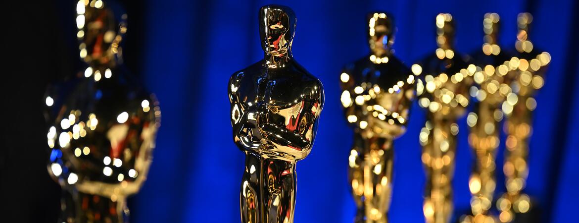 Photo of several Oscar statues in a line.