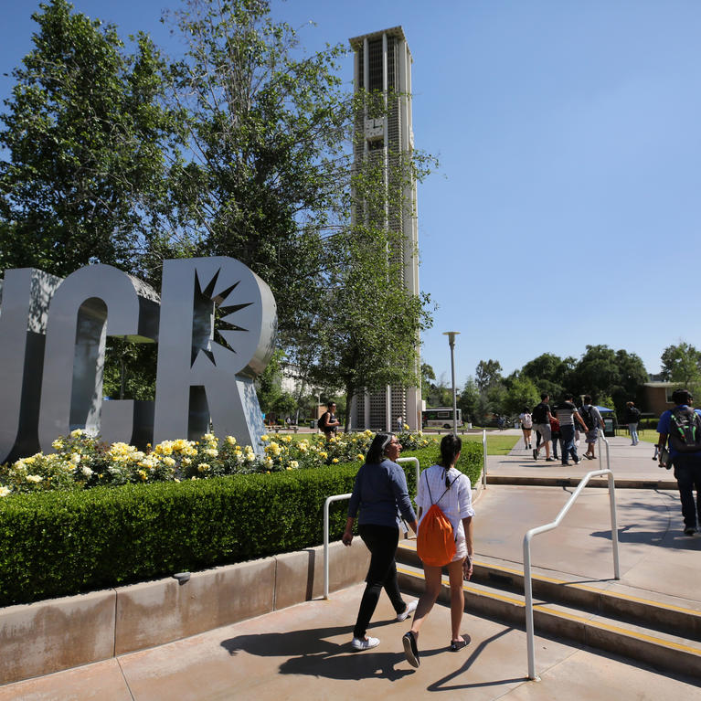 Students walking past UCR sign