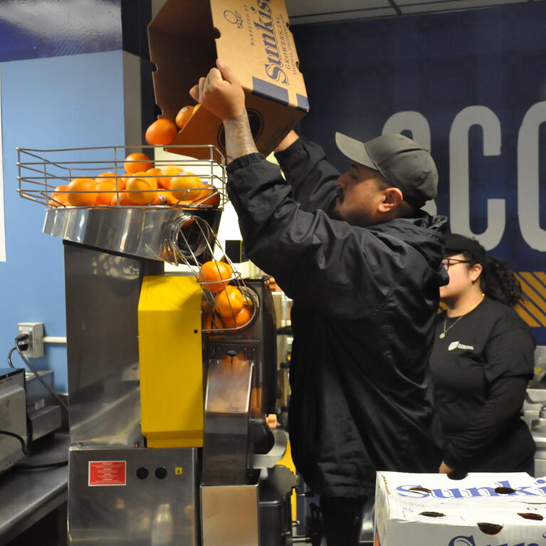 Employee making OJ at Scotty's store