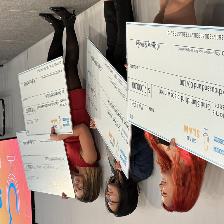 UC Grad Slam winners holding giant award checks