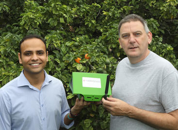 Shailendra Singh (left) and Eamonn Keogh (right) hold a FarmSense FlightSensor insect trap