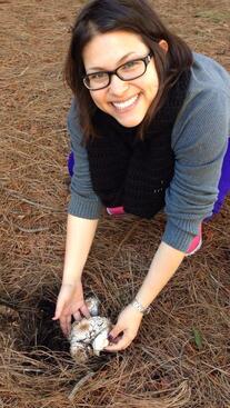 Mycologist Sydney Glassman holding a mushroom