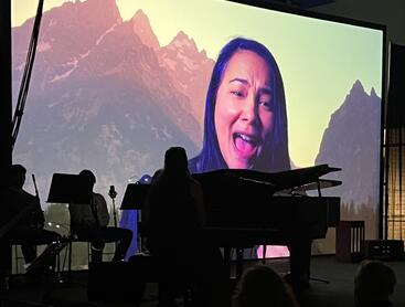 Photo of video projection of actress Rinska Carrasco in a performance of "I Hear America Singing."