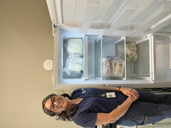 Rubie Onate stands next to freezer