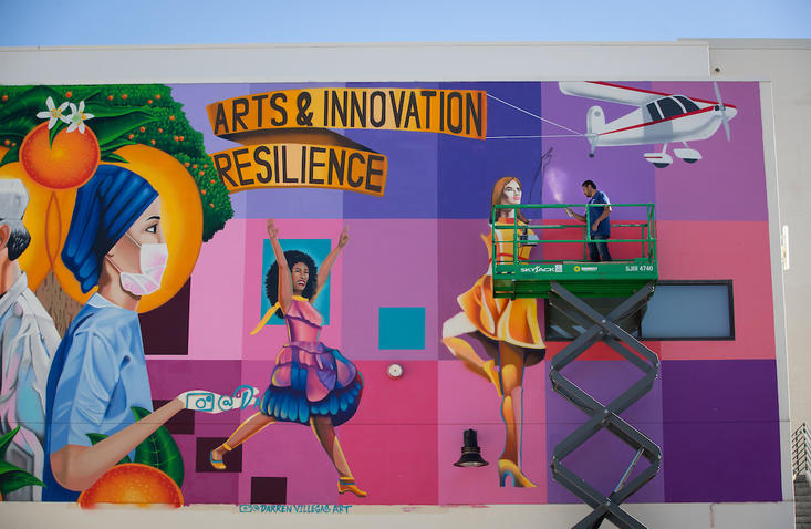 Darren Villegas works on mural