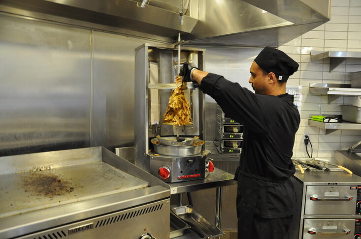 cutting meat from skewer